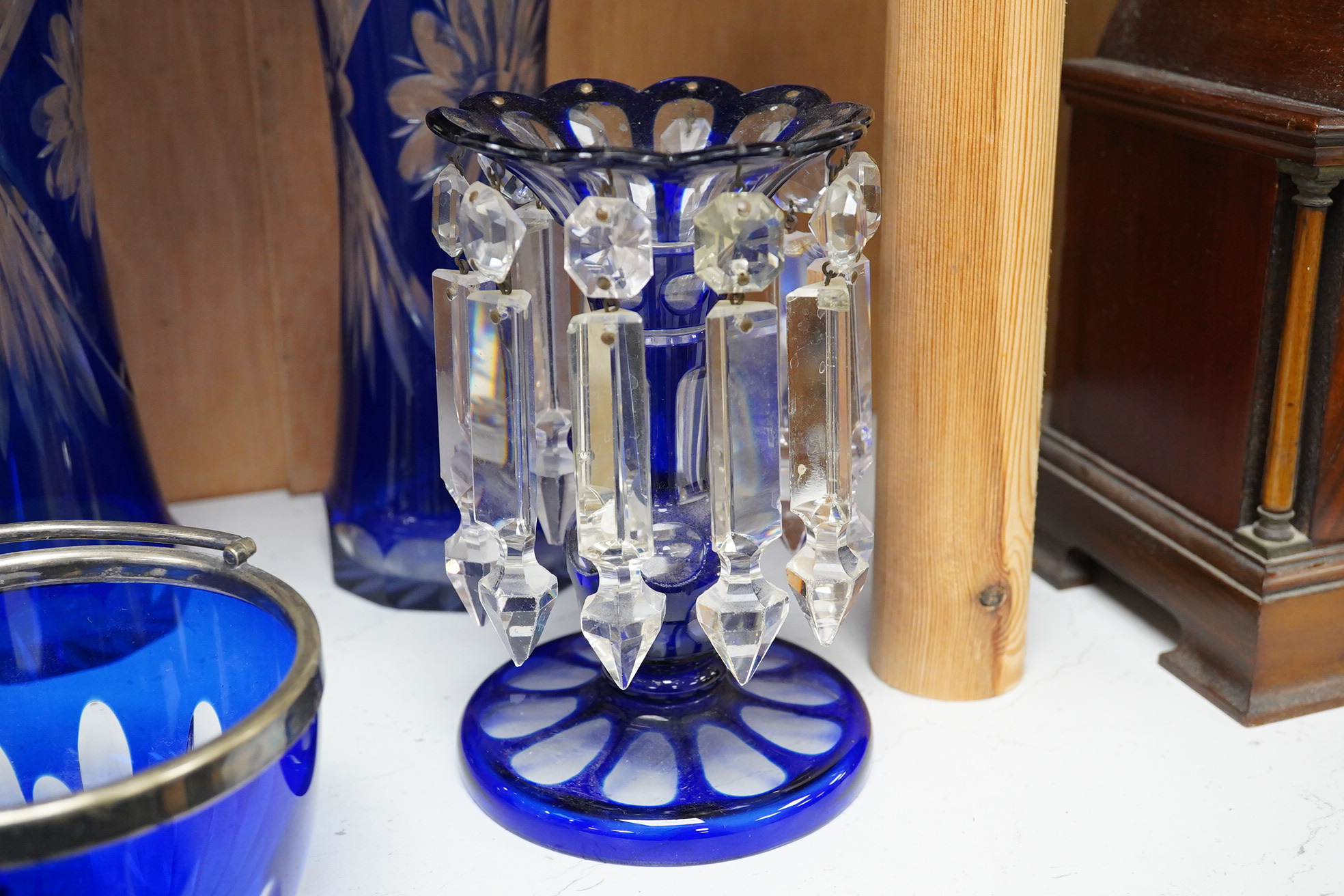 A pair of blue overlaid glass table lustres with drops and other blue overlaid glassware to include a pair of candlesticks and vases, largest 27cm high